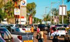 Pedestrians walk past parked vehicles outside a Total SA gas station in Maputo, Mozambique, on Thursday, March 23, 2017. Mozambique missed a $119 million payment due Tuesday on a loan Credit Suisse Group AG arranged, the second debt repayment the government failed to make in as many months.