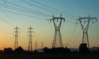 Electricity transmission towers and power lines against during sunset.