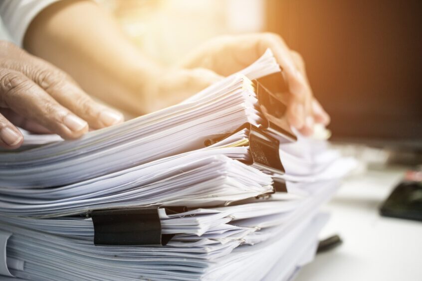 Work from Home, Businessman hands working in Stacks of paper files for searching information on work desk home office, business report papers,piles of unfinished documents achieves with clips indoor.; Shutterstock ID 692559100; Purchase Order: -