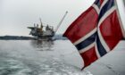 A Norwegian national flag flies from the back of a boat in view of the the Aasta Hansteen gas platform operated by Statoil ASA during its ceremonial baptism near Stord, Norway, on Thursday, March 8, 2018. Oil companies operating in Norway raised investment forecasts for this year after a wave of projects were approved, and expect spending to rise for the first time since crude prices collapsed in 2014. Photographer: Carina Johansen/Bloomberg