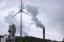 A chimney emits vapor at the Scholven coal-fired power plant operated by Uniper SE, beyond a wind turbine and the Ruhr oil refinery operated by BP Gelsenkirchen GmbH, a subsidiary of BP Plc, in Gelsenkirchen, Germany, on Saturday, May 21, 2022.
