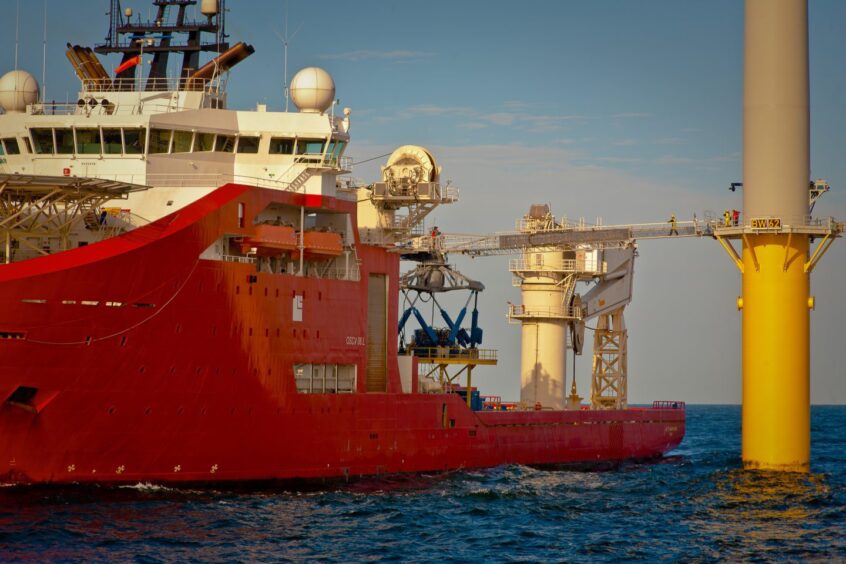 A service vessel connected to an offshore wind turbine via a motion compensated gangway.