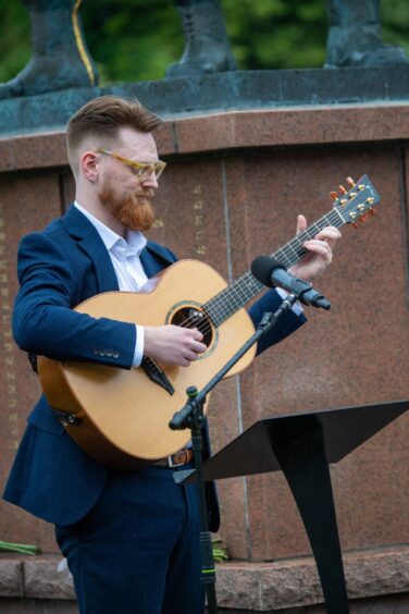 Calum McIlroy plays the guitar while at the Piper Alpha memorial service in Aberdeen.