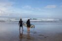 People learn to surf at the beach in the Kuta area of Bali, Indonesia.