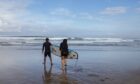 People learn to surf at the beach in the Kuta area of Bali, Indonesia.