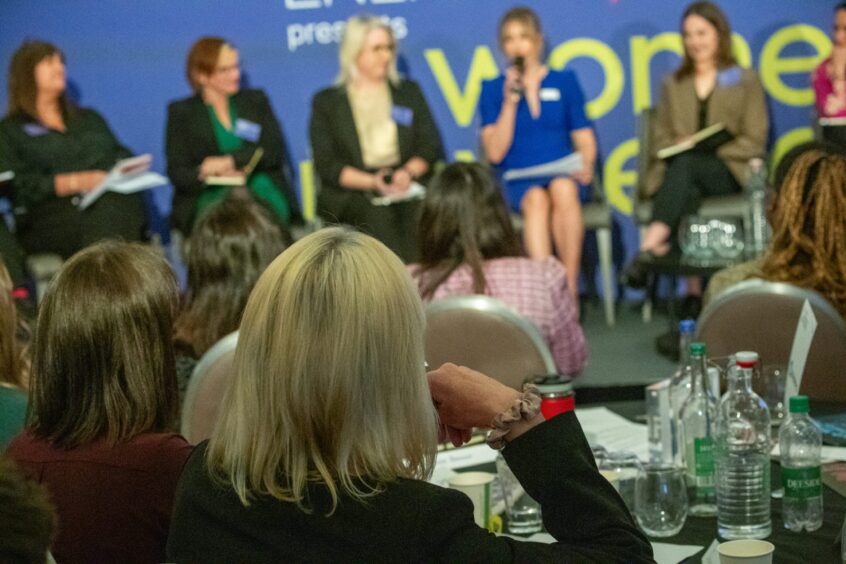 Speakers on a panel on a stage