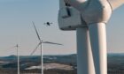 A drone performing a blade inspection on a wind turbine.