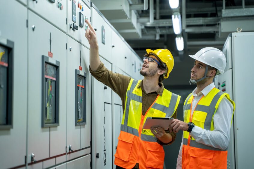 Engineer and technical worker checking status switchgear electrical energy distribution substation. Hexagon offers tech solutions for oil & gas firms