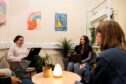 three students sit around a table in one of ISA's new learning spaces