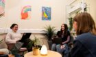 three students sit around a table in one of ISA's new learning spaces