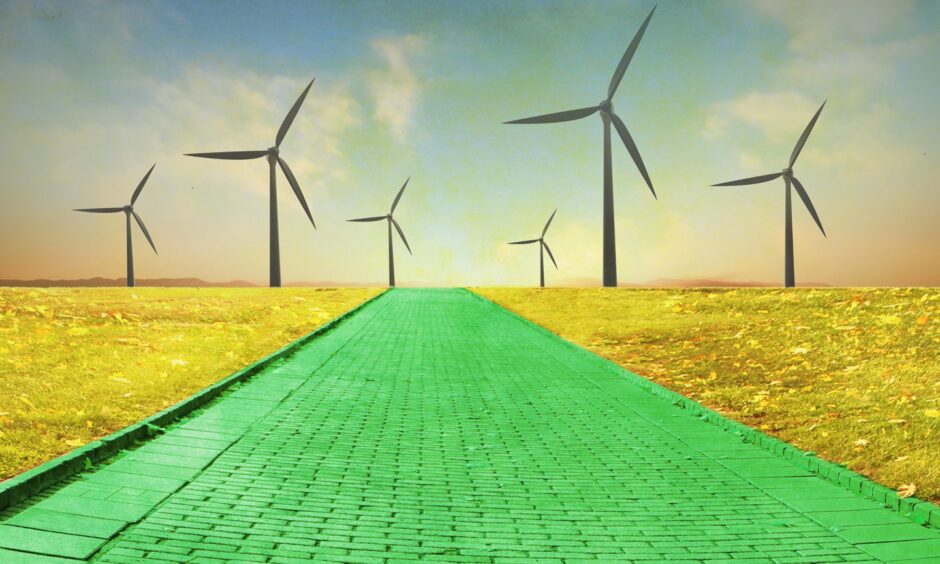 Green brick road leading to wind turbines.