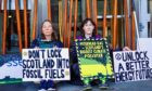 Extinction Rebellion campaigners locked themselves to the Scottish Parliament.