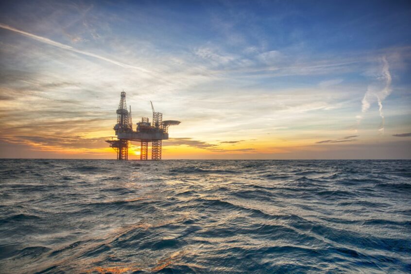 oil rig at sea with a sunset