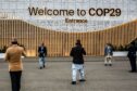 Participants take photos in front of a main entrance during the United Nations Climate Change Conference COP29, an event held by United Nations Framework Convention on Climate Change (UNFCCC) in Baku Olympic Stadium. COP29, running from November 11-22 focuses on carbon markets and sustainability and mitigation funding. Dominika Zarzycka/SOPA Images/Shutterstock