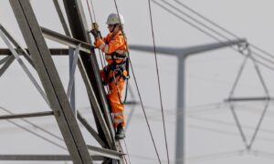 A National Grid technician climbing an electricity pylon.