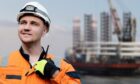 Man in front of oil rig.