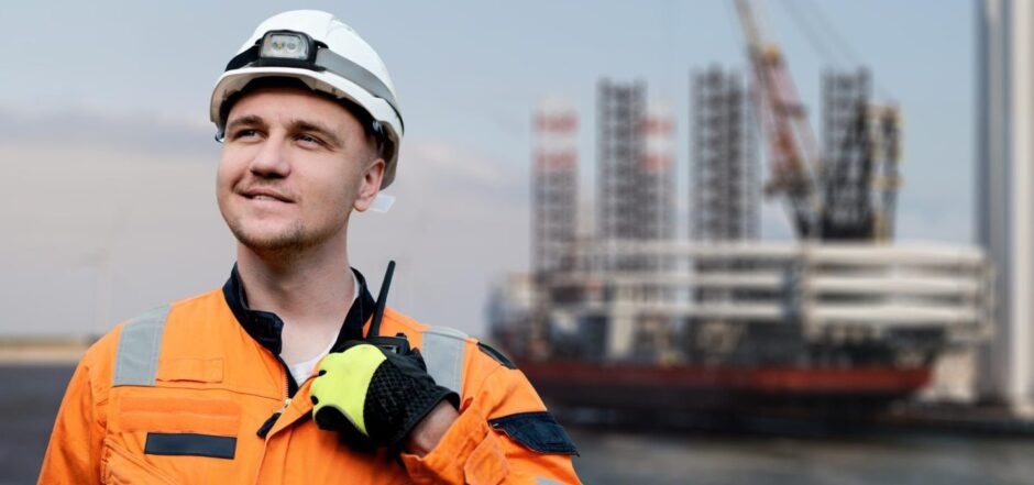 Man in front of oil rig.