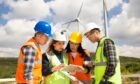 Young engineers and workers having a meeting at wind farm.