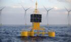 Telecommunications equipment mounted on a floating buoy with offshore wind turbines in the background.