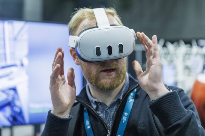  A delegate experiences ACUA Ocean's underwater inspection tech using a VR demo