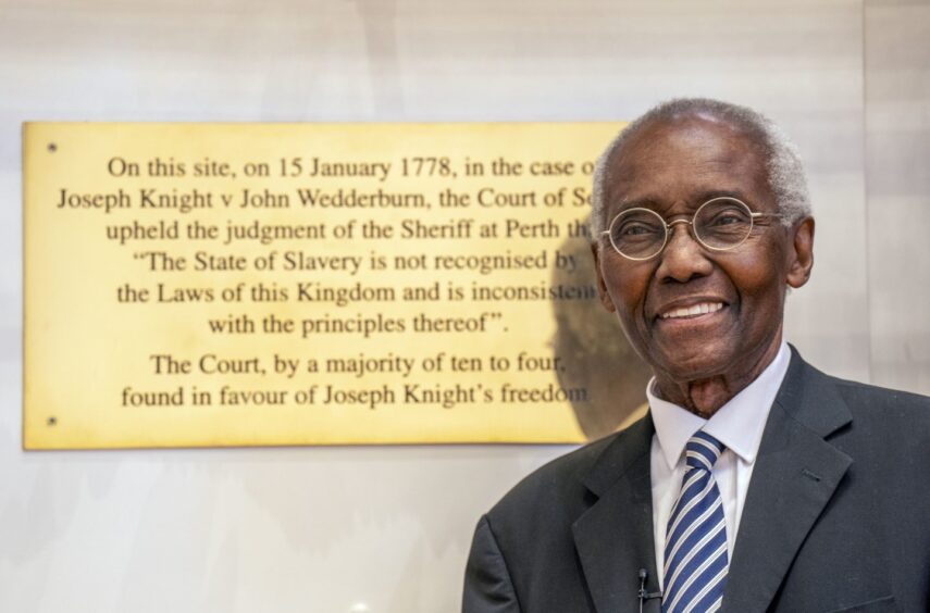 Sir Geoff Palmer stands beside a plaque commemorating the Knight v Wedderburn case.