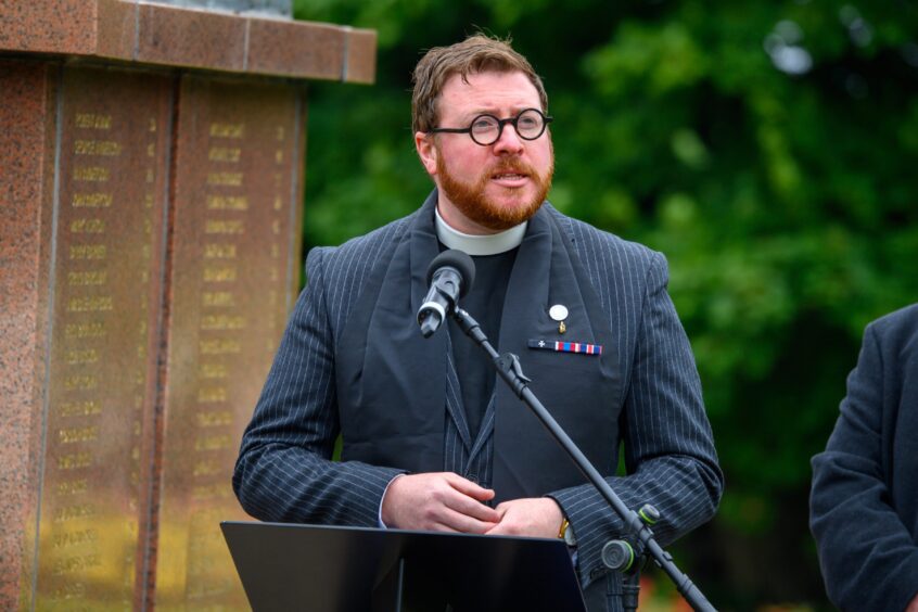 Reverend Michael Mair speaks at a podium during the 2025 Piper Alpha memorial in Hazlehead Park, Aberdeen.