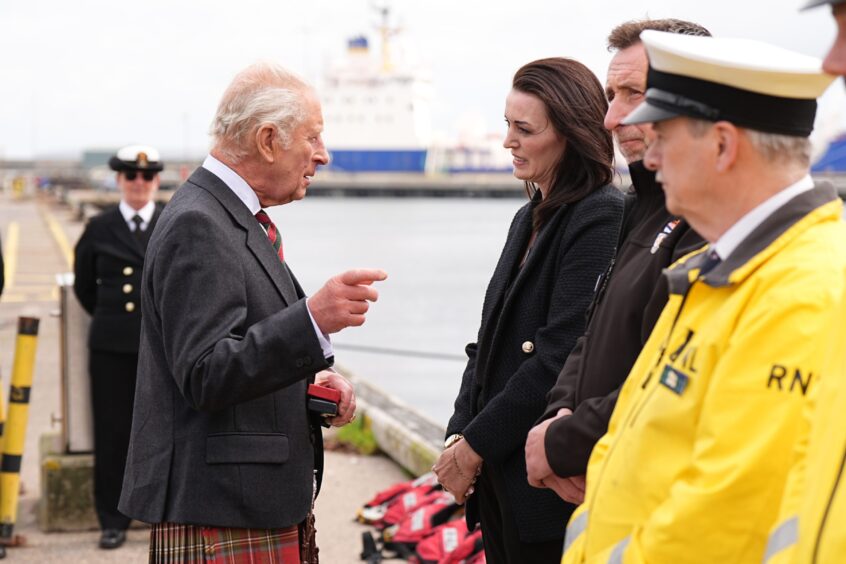 King Charles III presents Dee Munro with a Coronation Medal for her father William Munro, ahead of a reception for Caithness Communities hosted by the Nuclear Decommissioning Authority at Scrabster Harbour in Thurso, marking the 70th anniversary of the Dounreay Nuclear site, the 50th anniversary of the Pacific Nuclear Transport Limited (PNTL) and the 20th Anniversary of the Nuclear Decommissioning Authority.