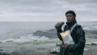 Motherf***in' Samuel L Jackson looking at some motherf***in' wind turbines while holding some motherf***in' seaweed snacks.