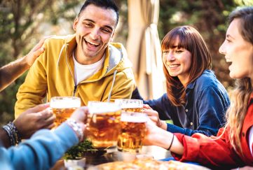 Four friends toasting each other with a glass of beer