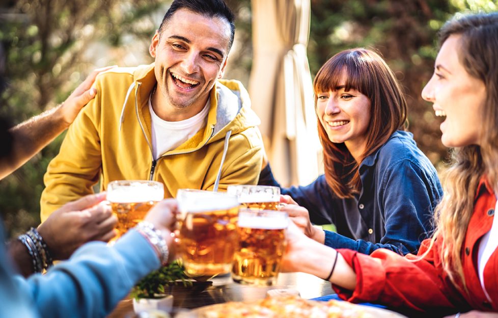 Four friends toasting each other with a glass of beer