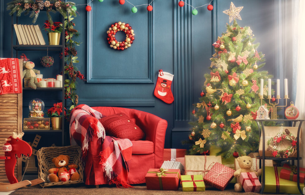 A living room decorated for Christmas with tree, stocking, presents, garland and wreath