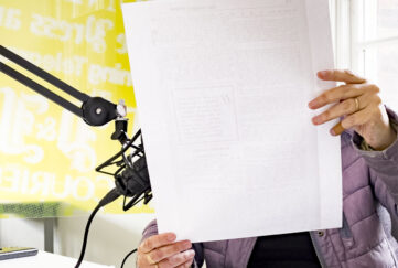 Podcast studio reading from paper into microphone
