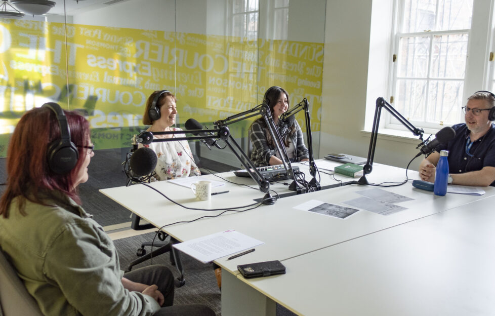 Reading Between The Lines team sat around podcast studio