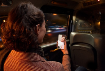 Women in car seat talking on video call phone with hearing aid