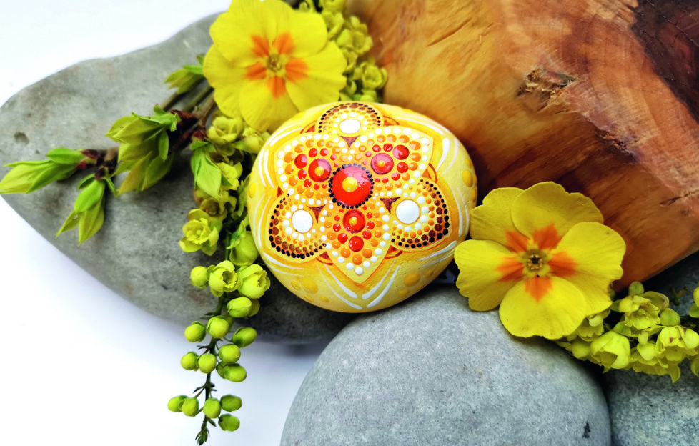 Painting stones with mandala and decorative flowers and stones