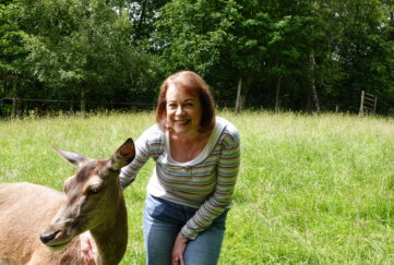 The People's Friend Editor, Angela, smiling with deer at Polly Pullar's farm