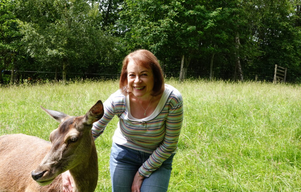 The People's Friend Editor, Angela, smiling with deer at Polly Pullar's farm