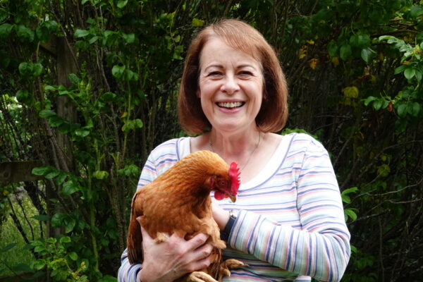Close up of The People's Friend Editor Angela smiling holding a hen