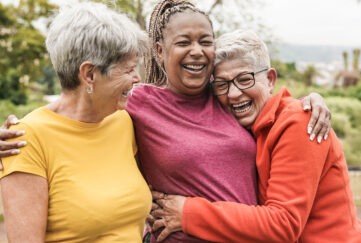 Elderly women hugging and laughing