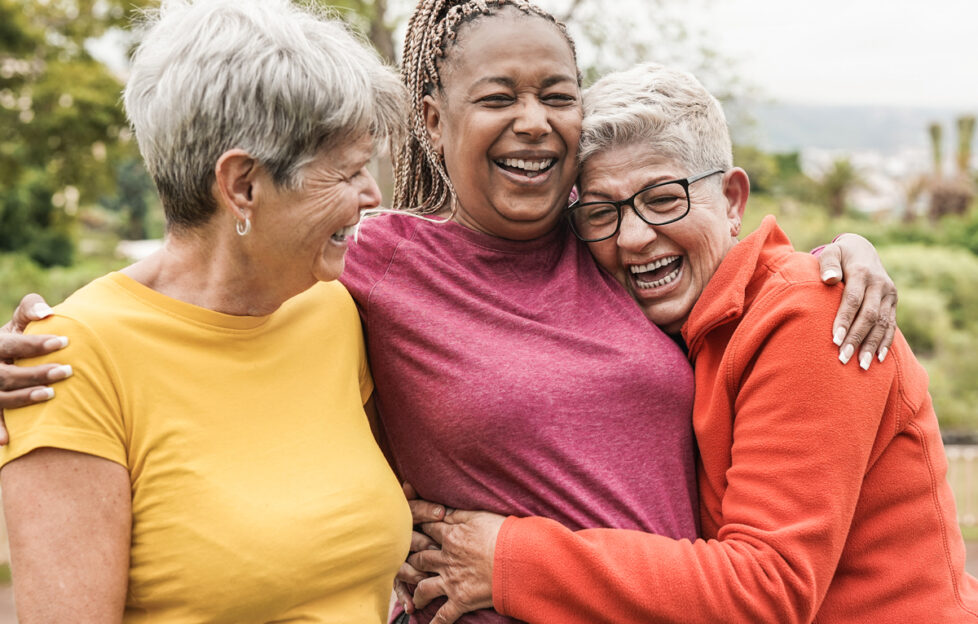 Elderly women hugging and laughing