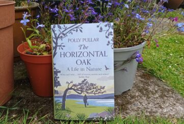 The Horizontal Oak book by Polly Pullar standing against plant pots in a garden