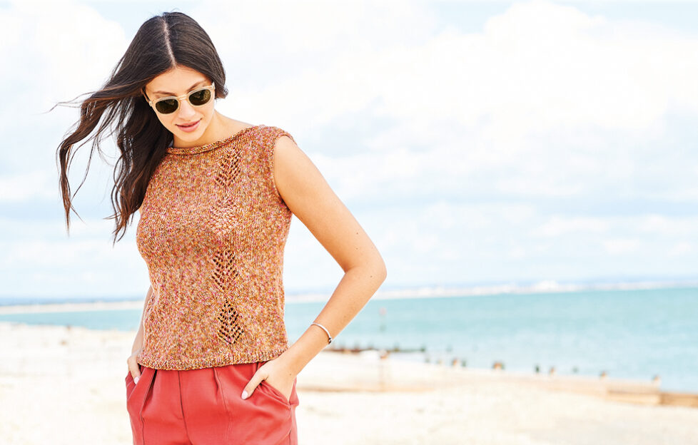 Model on beach wearing knitted top