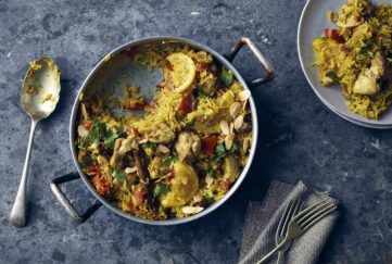 Flatlay of chicken and lemon biryani pot, serving spoon and plated