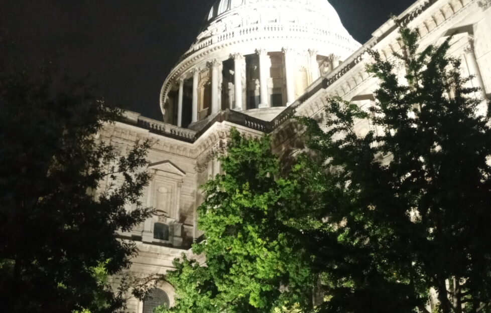 St Paul's Cathedral in London dome at night time, lit up with trees in front