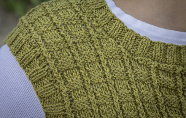 Close up of knitted tank top shoulder in avocado colour