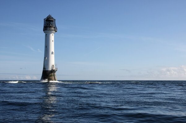 Bell Rock Lighthouse on the water on a blue sky sunny day