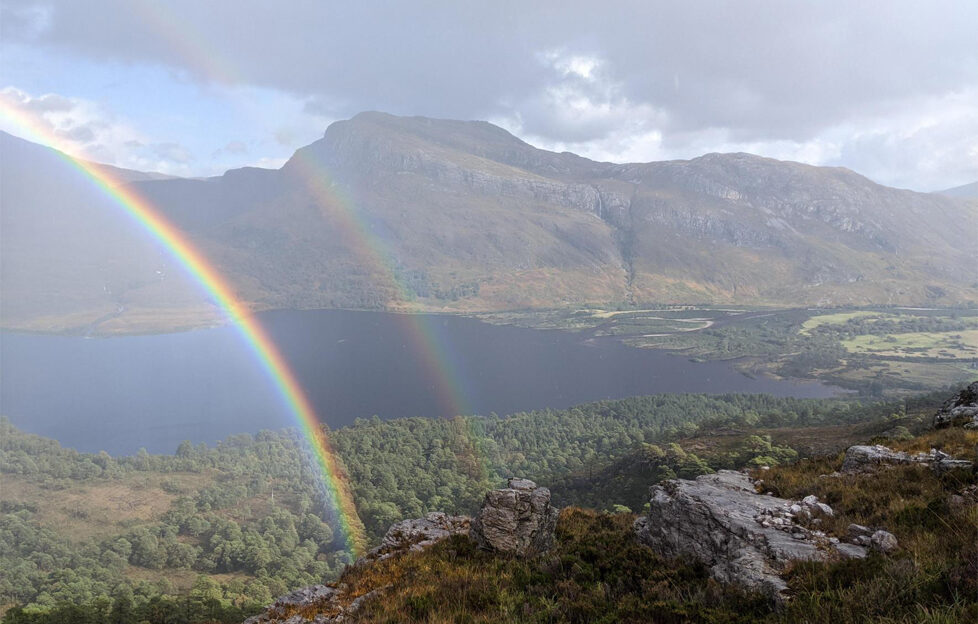 A view from up the Beinn Eighe Nature Reserve Mountain trail of Loch Maree and two rainbows from the left of the f rame