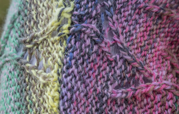 Close up of knitting pattern of cardigan in multicolours