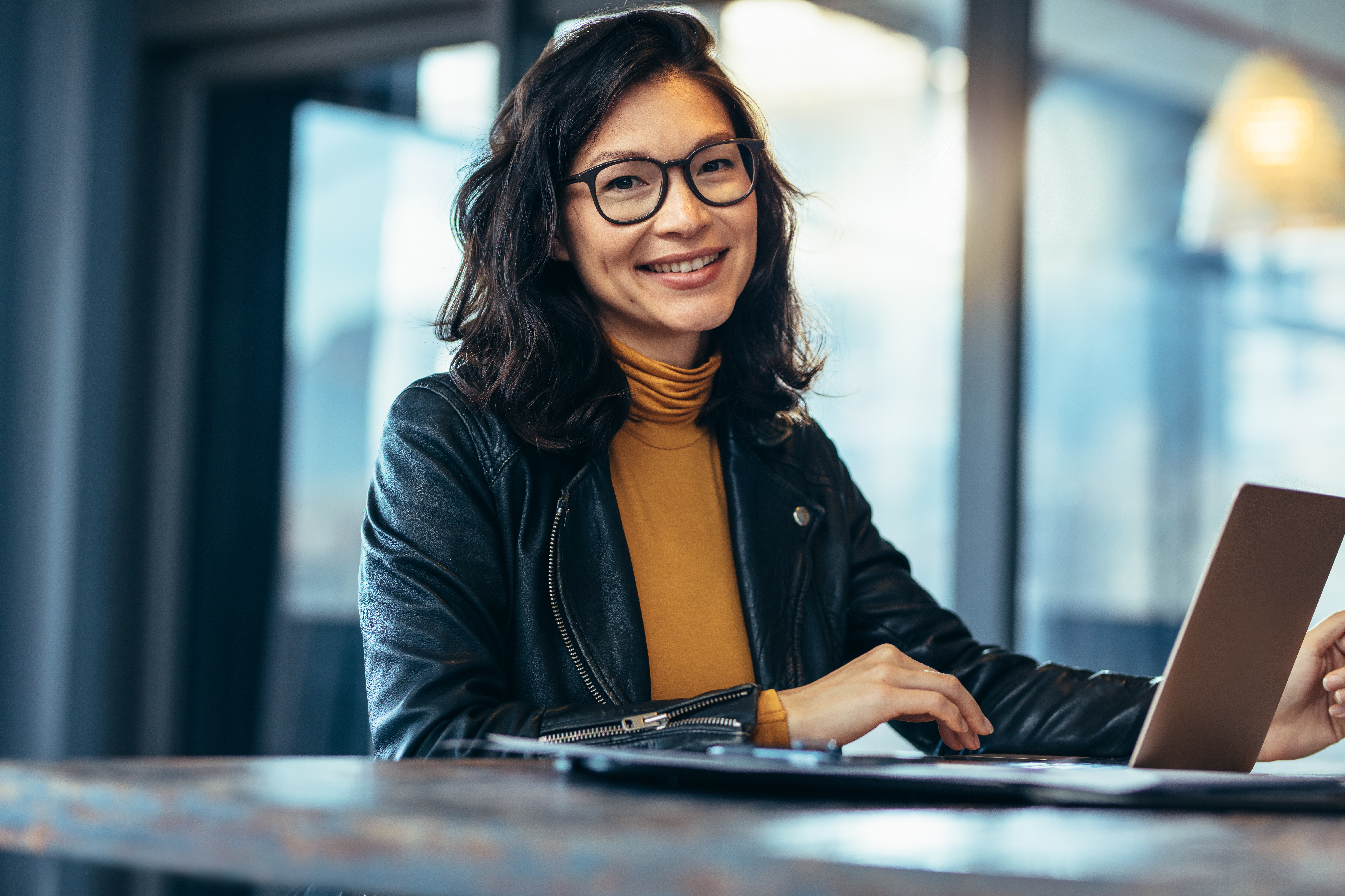 Professional woman smiling at desk on laptop