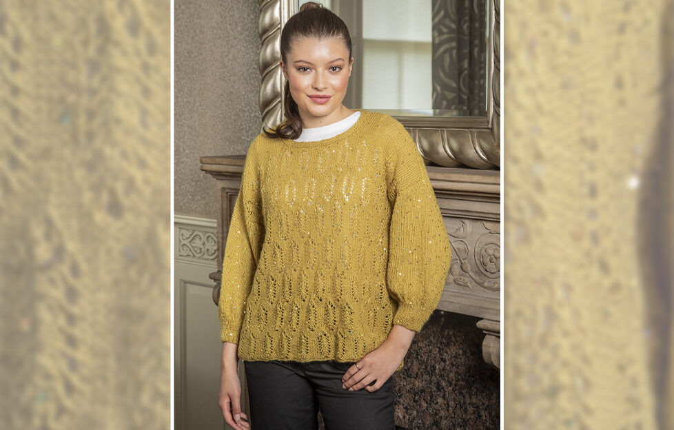 Mustard sparkly knitted Christmas party sweater worn by brown haired model in front of ornate fireplace